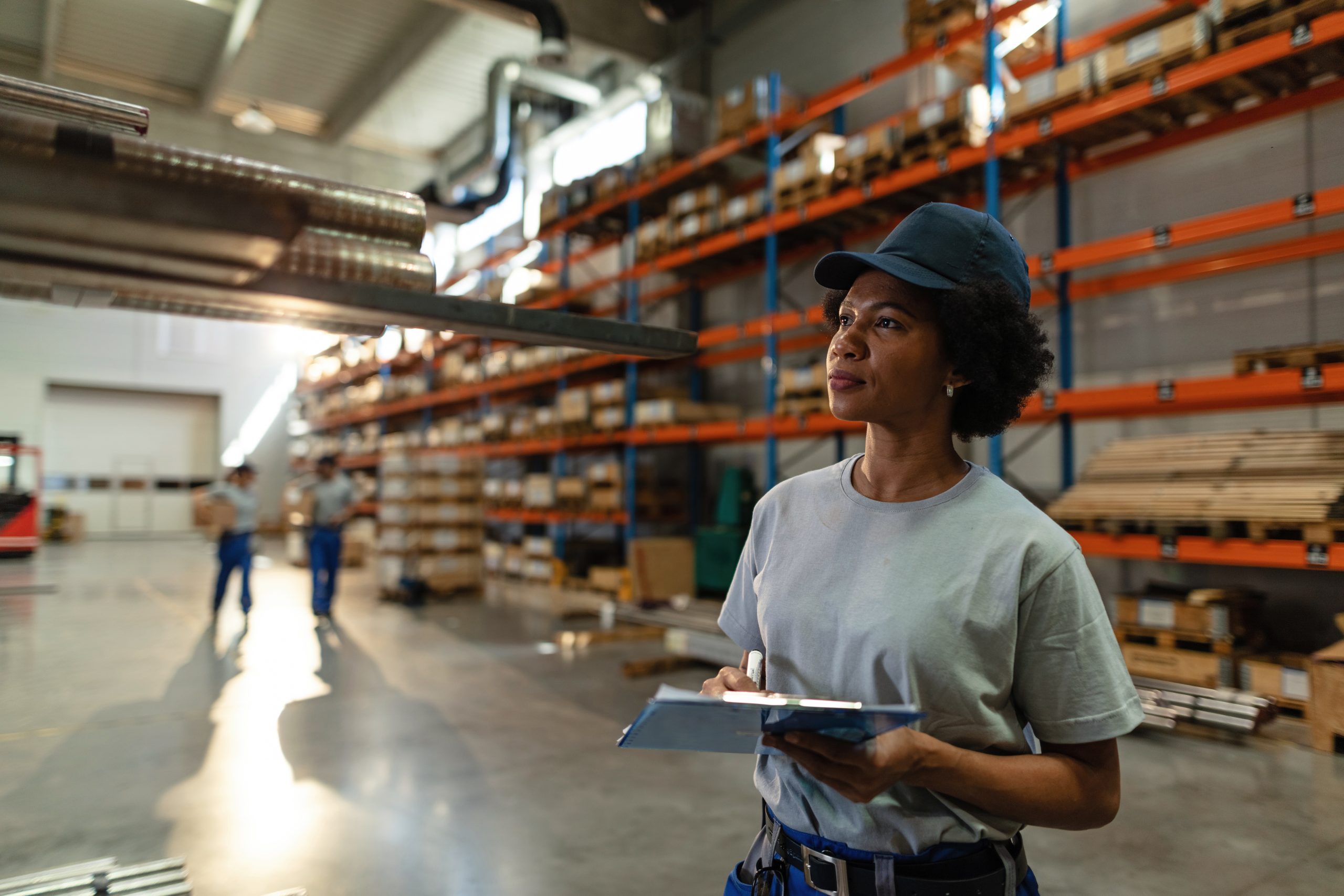 african american female worker taking notes while inspecting ste